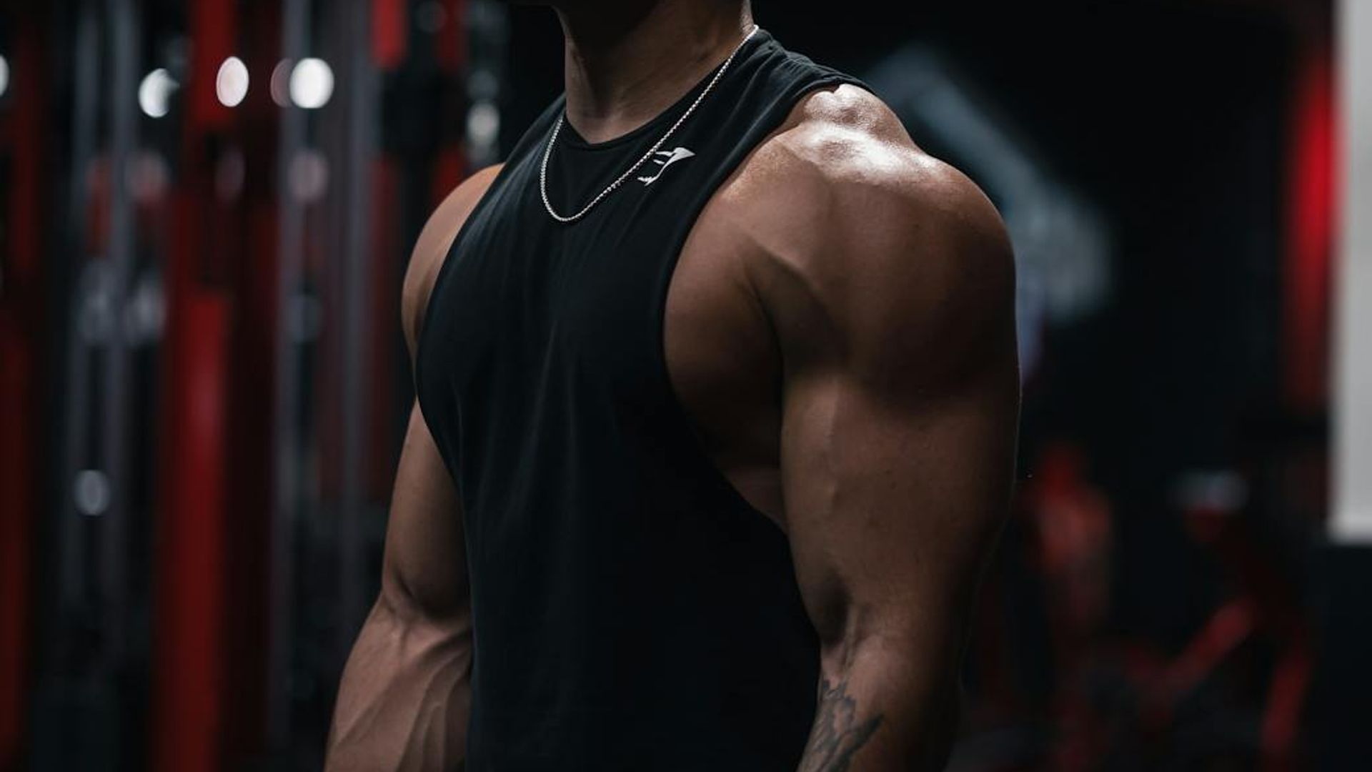 Man in a state of deep focus during a strength exercise in a dark gym.